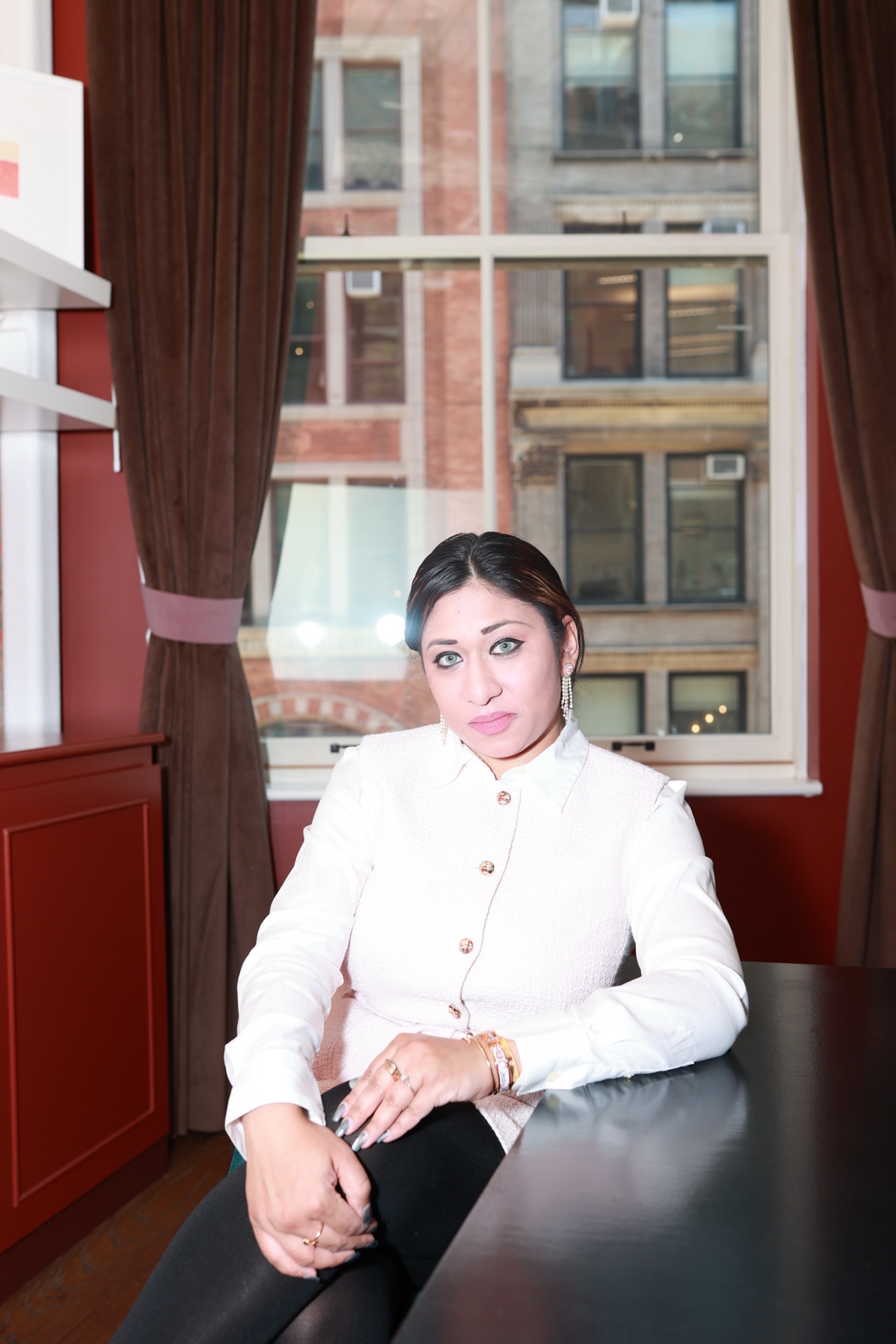 Mina Haque — seated, intense direct gaze