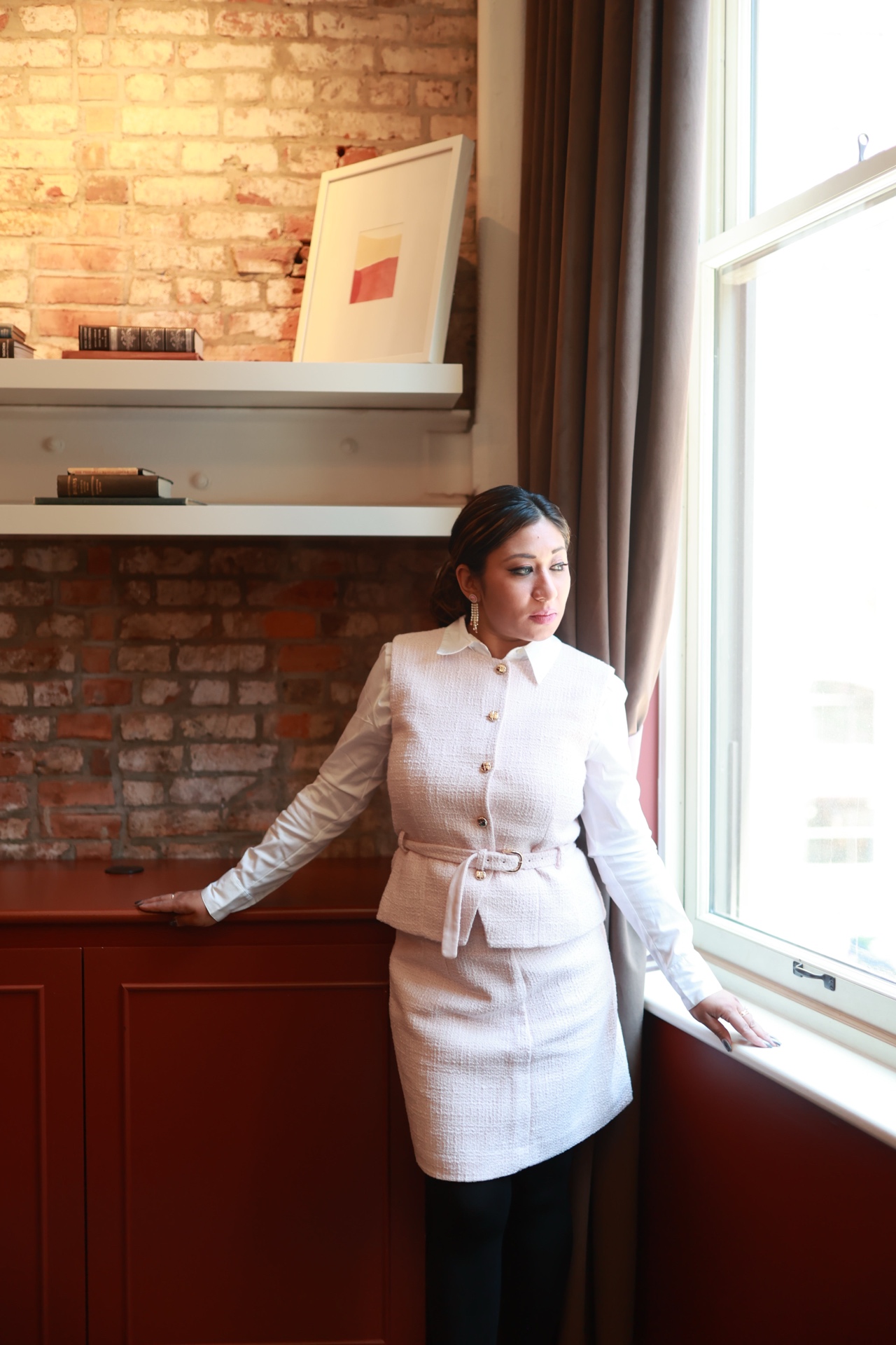 Mina Haque — standing by window, contemplative