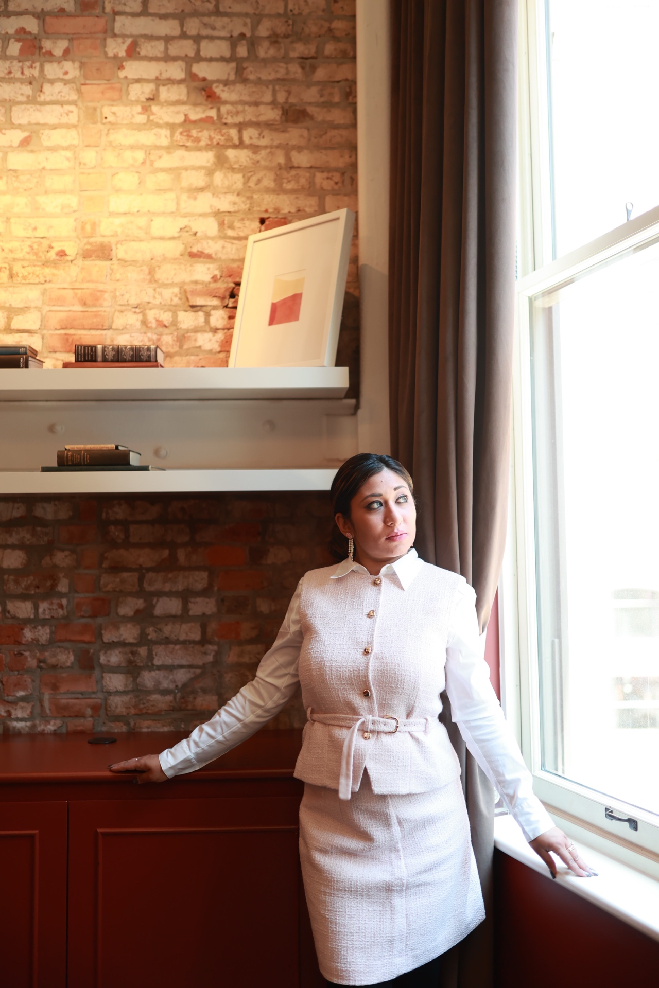 Mina Haque — standing by window, direct gaze